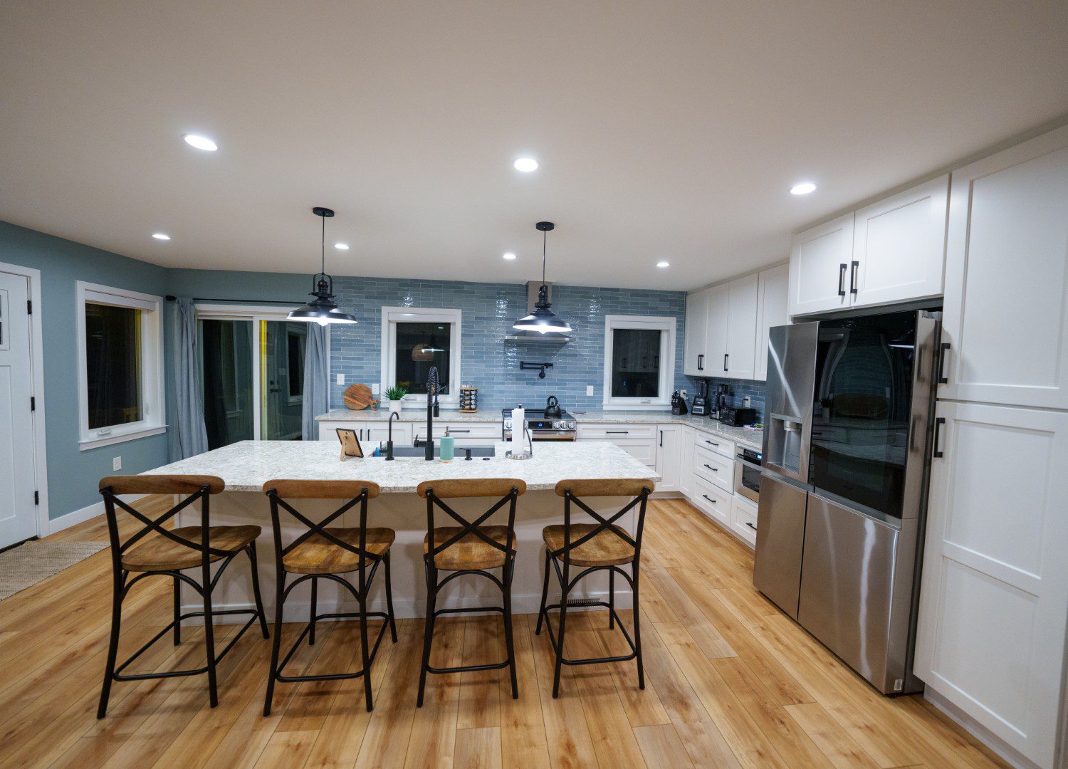 Modern kitchen with island and wooden flooring.